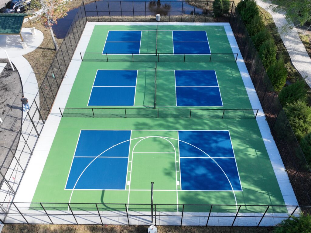 Aerial view of a vibrant multi-court tennis facility with six courts.