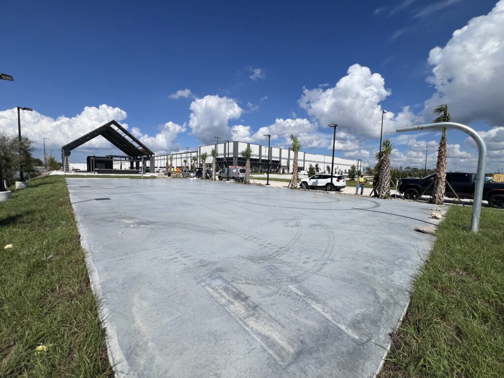 New concrete slab with construction equipment and blue sky in background.