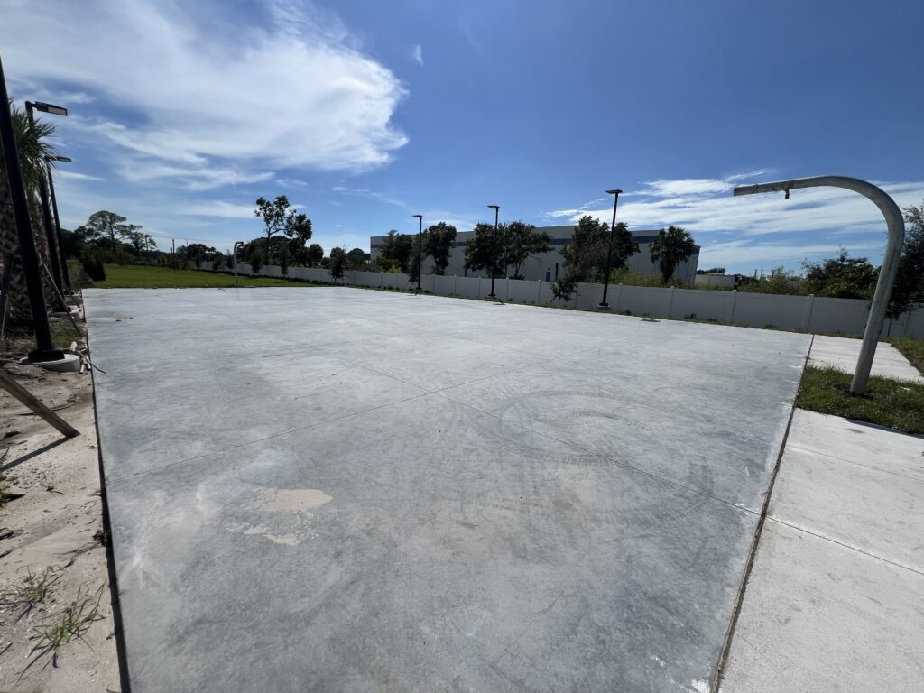 A newly poured concrete slab under a partly cloudy sky.