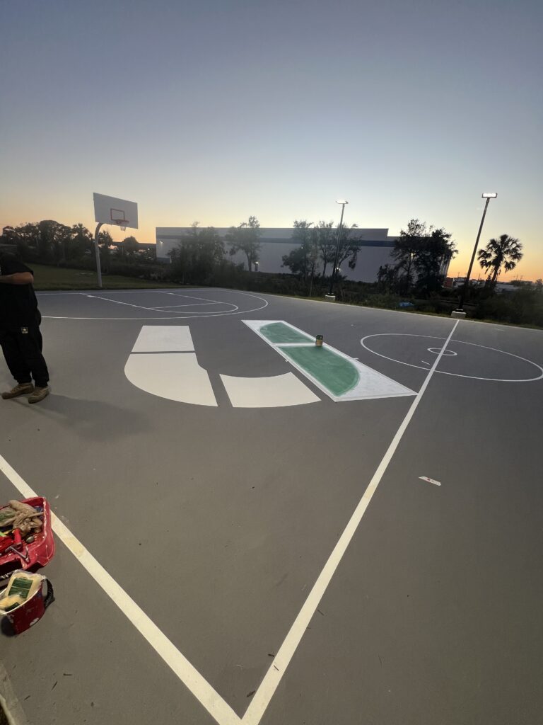 A basketball court with a unique logo painted at center court.