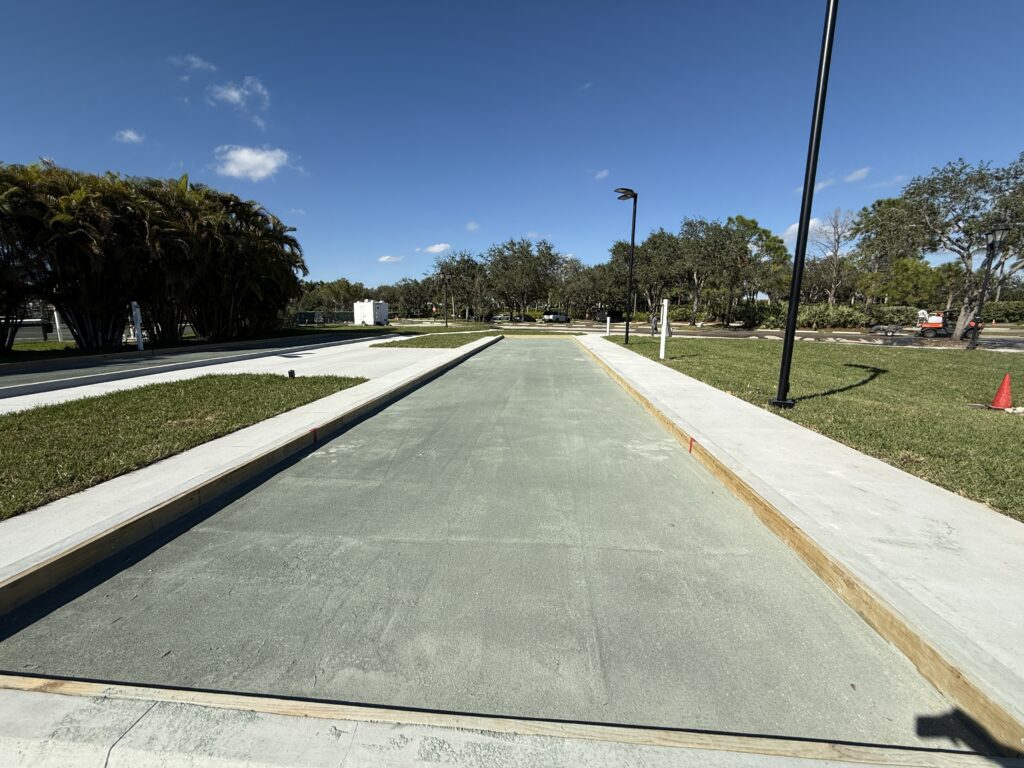 A newly paved concrete pathway under a clear blue sky.