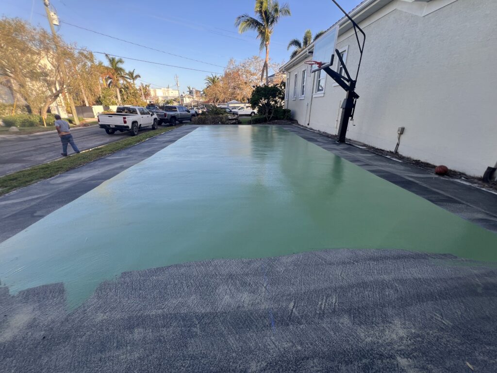A modern rectangular swimming pool with a black basketball hoop beside it.