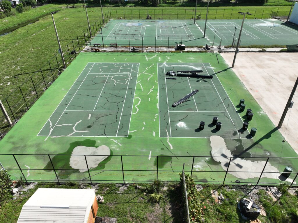 Worn-out outdoor pickleball courts with cracked surfaces and faded lines.